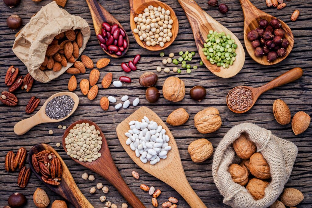 Various legumes and different kinds of nutshells. Walnuts kernels ,hazelnuts, almond ,brown pinto ,soy beans ,flax seeds ,chia ,chickpea ,red kidney beans and pecan.