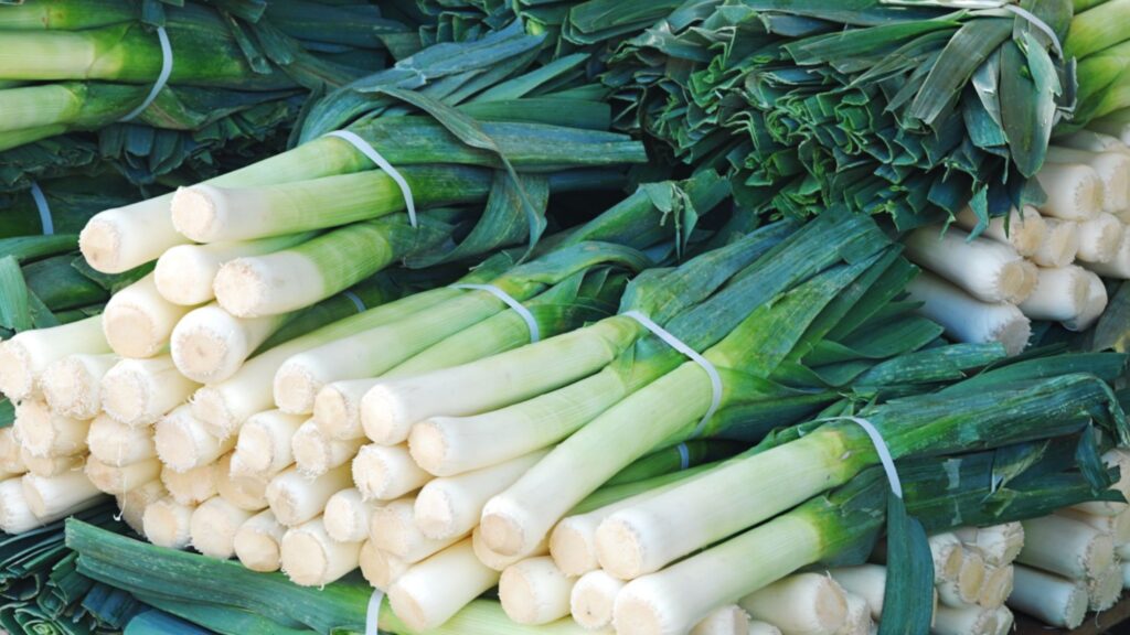 several bunches of leeks sitting on top of each other