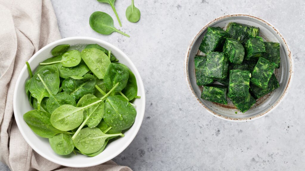a bowl of fresh spinach along side with a bowl of frozen spinach