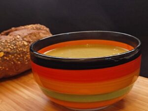 A bowl of spinach soup served with bread