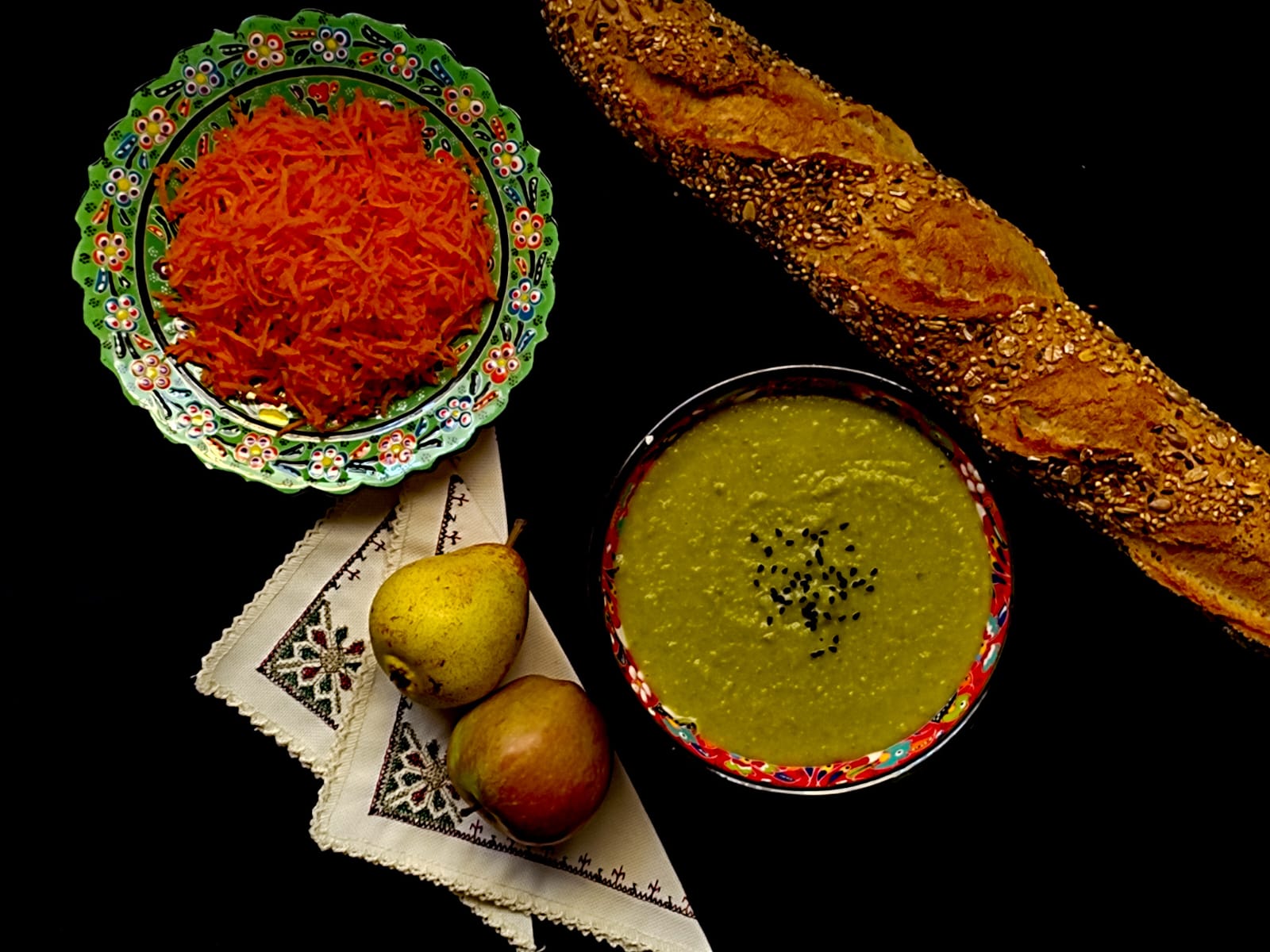 split pea soup served in a bowl with bread, carrots and some fruits